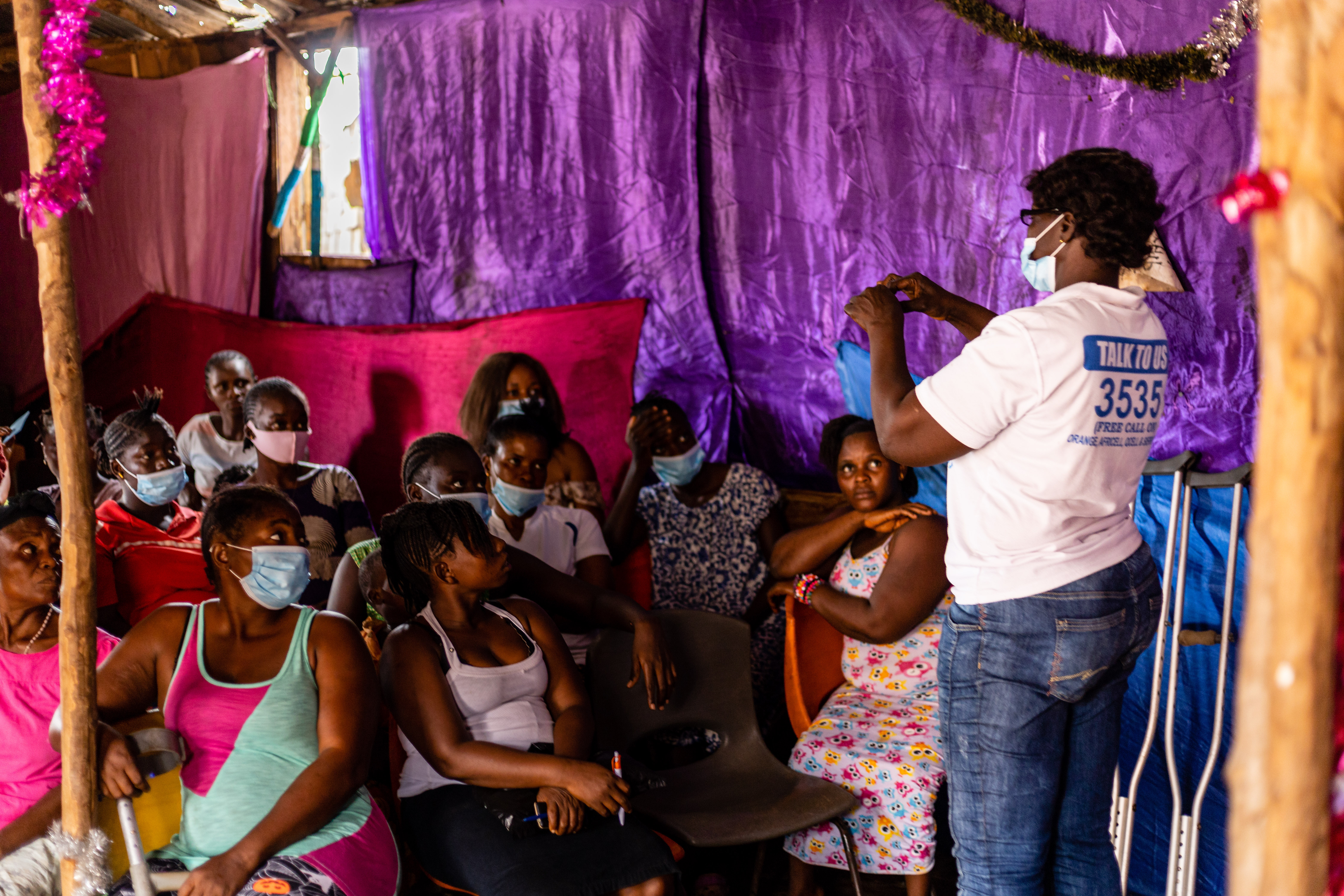 Person speaking in a room to others